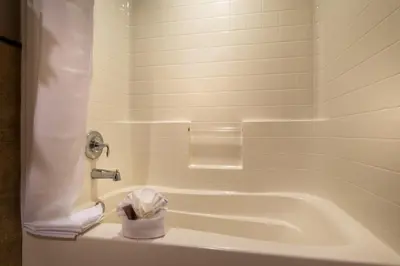 a bathroom with a bath tub and a towel at Ayres Hotel Seal Beach - Cypress in Seal Beach