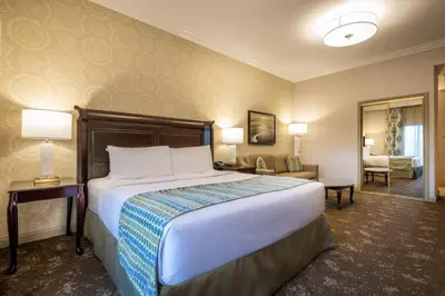 a hotel room with a bed and a living room at Ayres Hotel Seal Beach - Cypress in Seal Beach
