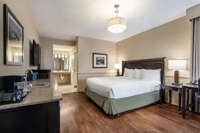 a hotel room with a bed and a sink at Best Western Corona Hotel & Suites in Corona