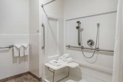 a white bathroom with a shower and a sink at Best Western Corona Hotel & Suites in Corona