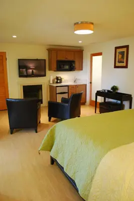 a bedroom with a bed and a kitchen with a fireplace at Bella Capri Inn and Suites in Camarillo
