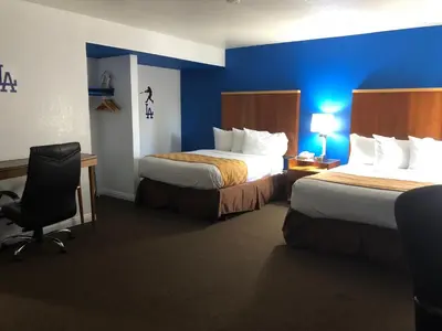 a hotel room with two beds and a chair at Knights Inn Los Angeles Central / Convention Center Area in Los Angeles
