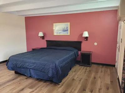 a bedroom with a bed and a red wall at Espana Motel in Norwalk