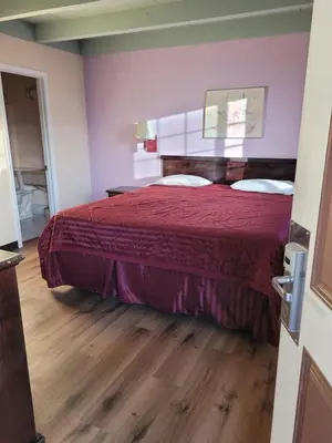 a bedroom with a bed with a red bedspread at Espana Motel in Norwalk