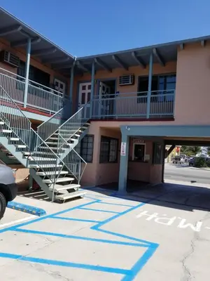 a building with stairs in a parking lot at Espana Motel in Norwalk