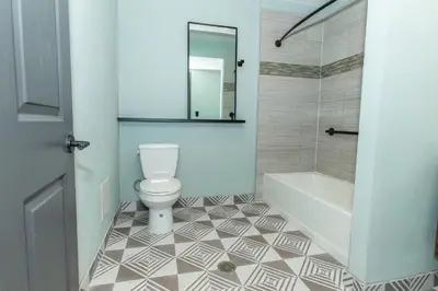 a bathroom with a toilet and a tub and a sink at Magnolia Tree Hotel-Maingate/Anaheim Convention Center in Anaheim