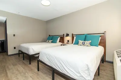 two beds in a room with blue and white at Magnolia Tree Hotel-Maingate/Anaheim Convention Center in Anaheim