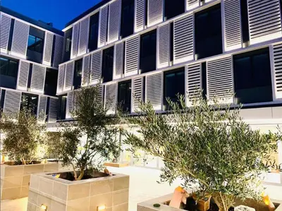 a building with windows and trees in front of it at Hotel Mariposa in Los Angeles