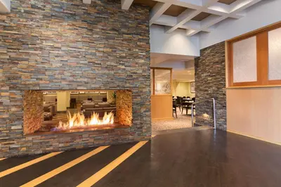 a fireplace in a lobby with a brick wall at USC Hotel in Los Angeles
