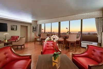 a room with red chairs and a table with a view at USC Hotel in Los Angeles