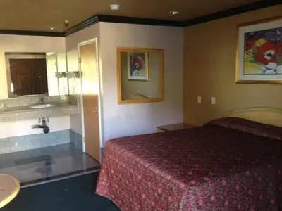 a hotel room with a bed and a bath tub at All 8 Motel in Azusa