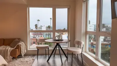 a living room with a table and chairs and windows at Lovely Studio in heart of Hollywood in Los Angeles