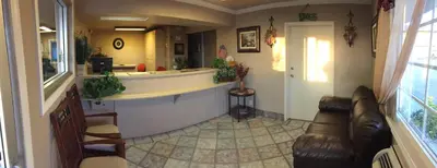 a living room with a bar and a couch at Hilltop Inn & Suites in Victorville