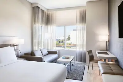 a hotel room with a bed and a living room at AC Hotel by Marriott Los Angeles South Bay in Los Angeles