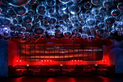 a large chandelier in a room with red lights at The West Hollywood EDITION in Los Angeles