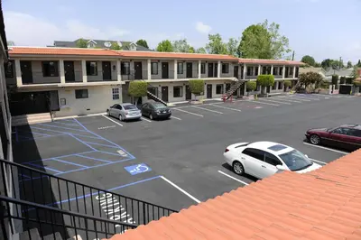 a parking lot with cars parked in front of a building at Best Budget Inn Anaheim in Anaheim