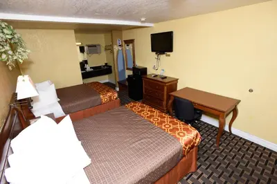 a hotel room with two beds and a desk at Best Budget Inn Anaheim in Anaheim