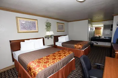 a hotel room with two beds and a desk at Best Budget Inn Anaheim in Anaheim