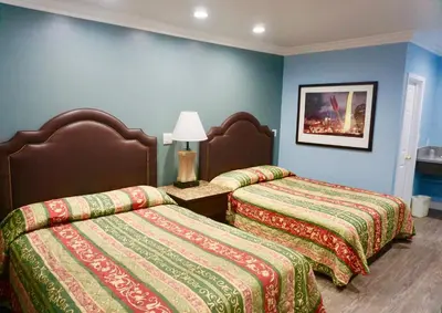 two beds in a room with blue walls at Redondo Beach Motel - LAX in Gardena