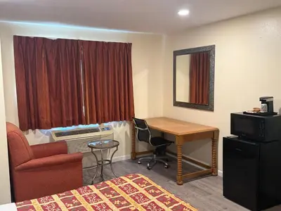 a hotel room with a desk and a chair at Anaheim National Inn in Anaheim