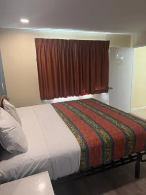 a large bed in a room with a window at Anaheim National Inn in Anaheim