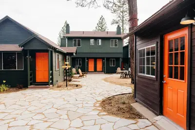 a house with orange and green doors and a patio at Noon Lodge in Big Bear Lake