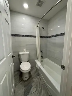 a bathroom with a toilet and a bath tub at Economy Inn - Burbank Airport in Sun Valley