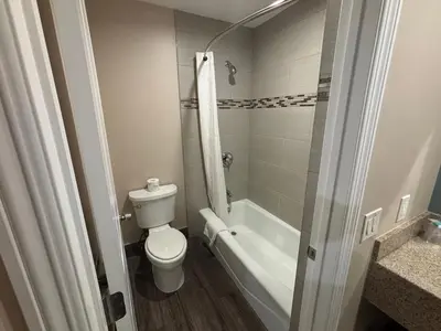 a bathroom with a toilet and a tub and a sink at Economy Inn - Burbank Airport in Sun Valley