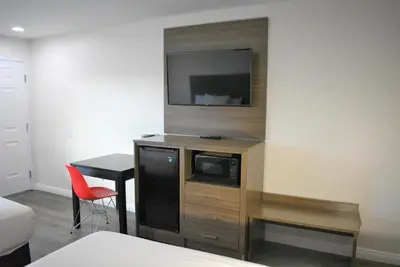 a room with a entertainment center with a tv on a wall at Signature Anaheim Maingate in Anaheim