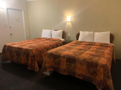 two beds sitting next to each other in a hotel room at Ventura Beach House Motel in Ventura