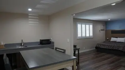 a room with a bed and a table and a sink at Sea Breeze Inn - LAX Airport, Los Angeles in Inglewood