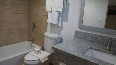 a bathroom with a toilet and a sink and a bath tub at Sea Breeze Inn - LAX Airport, Los Angeles in Inglewood