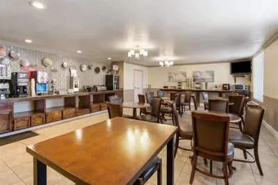 a restaurant with tables and chairs and a bar at Best Western Plus John Jay Inn & Suites in Palmdale