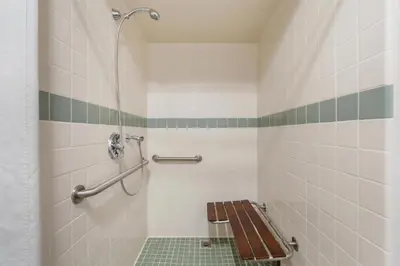 a bathroom with a bench and a shower at Best Western Plus John Jay Inn & Suites in Palmdale