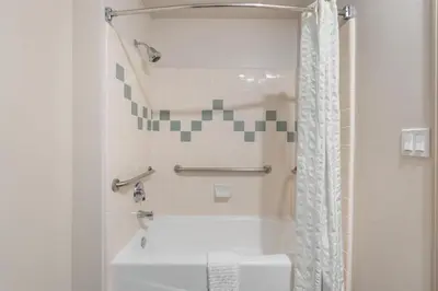 a bathroom with a white tub and a shower at Best Western Plus John Jay Inn & Suites in Palmdale