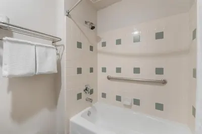 a white bathroom with a tub and a sink at Best Western Plus John Jay Inn & Suites in Palmdale