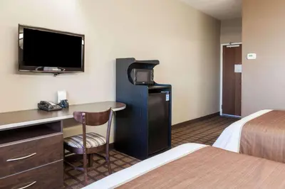a hotel room with a bed and a desk and a tv at Microtel Inn & Suites by Wyndham Wheeler Ridge in Wheeler Ridge