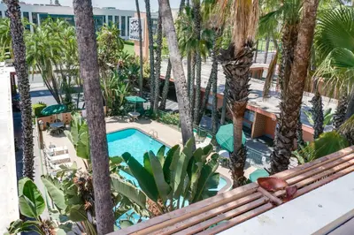 a view of the pool from the balcony of a hotel with palm trees at Saga Motor Hotel Pasadena in Pasadena