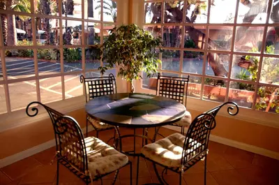a table and chairs in a room with a window at Saga Motor Hotel Pasadena in Pasadena