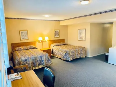 a hotel room with two beds and a table at Saga Motor Hotel Pasadena in Pasadena