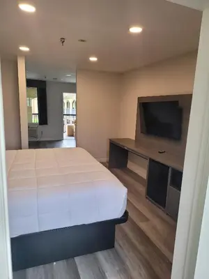 a bedroom with a large bed and a flat screen tv at Five Star Inn in West Covina