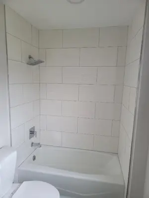 a white bathroom with a tub and a toilet at Five Star Inn in West Covina