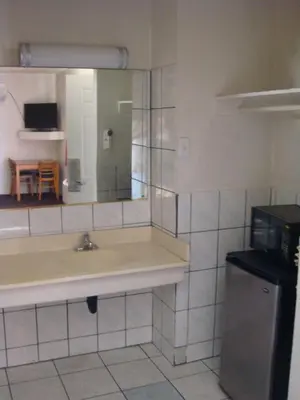 a bathroom with a sink and a mirror at American Inn in South El Monte