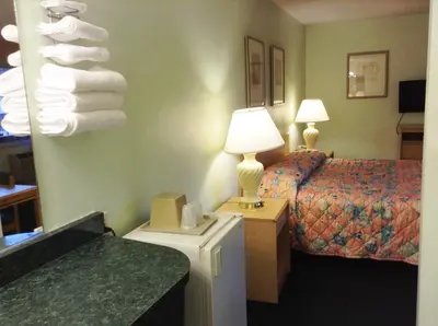 a hotel room with a bed and a stack of towels at Seahorse Inn Manhattan Beach - LAX in Manhattan Beach