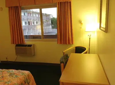 a hotel room with a table and a window at Seahorse Inn Manhattan Beach - LAX in Manhattan Beach
