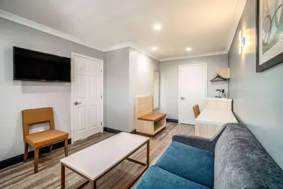 a living room with a couch and a table at Travelodge Inn & Suites by Wyndham Bell Los Angeles Area in Bell