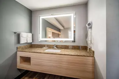 a bathroom with a sink and a mirror at Travelodge Inn & Suites by Wyndham Bell Los Angeles Area in Bell