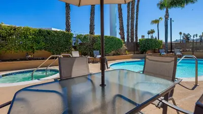 a glass table and chairs next to a swimming pool at Empire Inn in San Bernardino