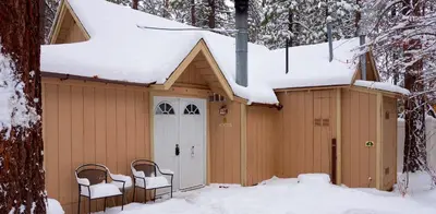 a house with snow on the roof of it at Sleepy Forest Cottages in Big Bear Lake