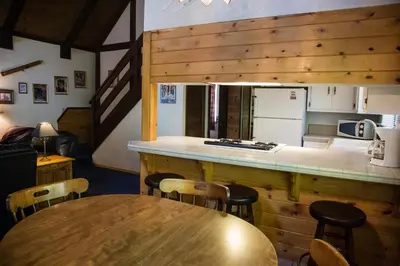 a kitchen with a wooden counter and a table with chairs at Sleepy Forest Cottages in Big Bear Lake